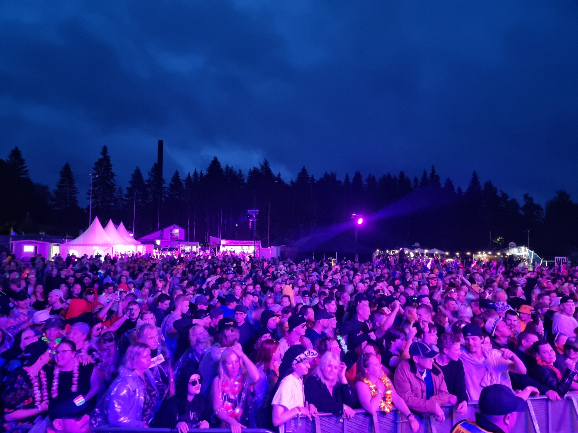 Festivaaliyleisö violetissa iltavalossa